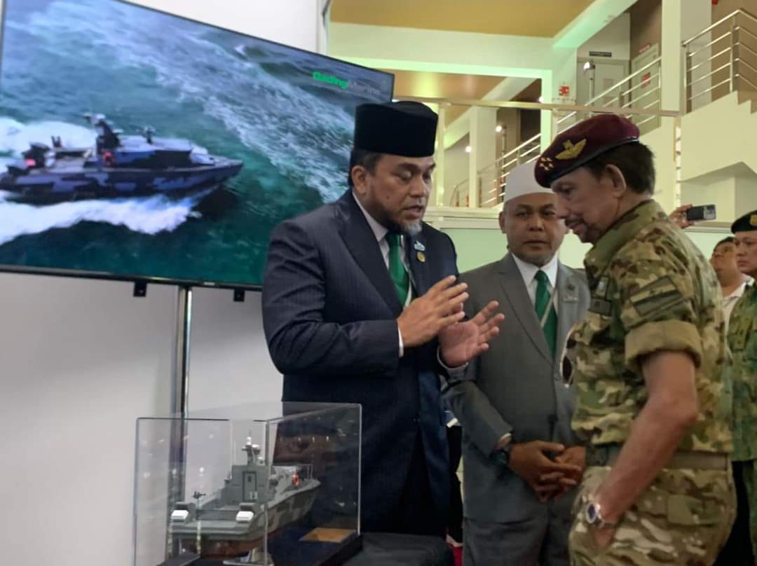 Sultan Hassanal Bolkiah diberi penerangan oleh Pengerusi Gading Marine, Tan Sri Mohd Reza Mohd Sany (kiri) tentang bot FIC G2000 MkII.