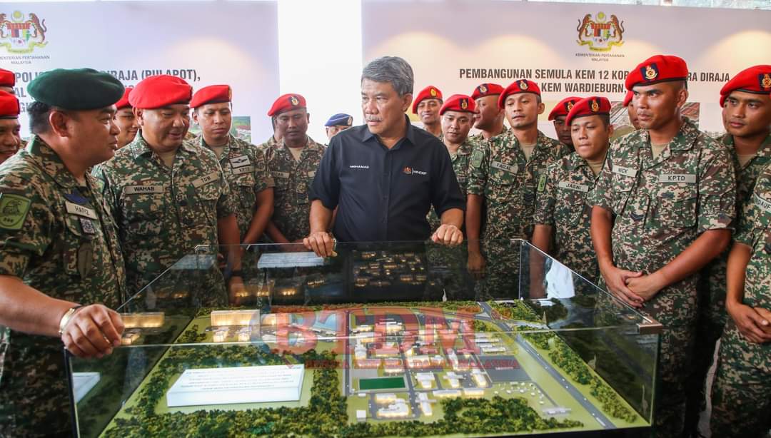 Mohamad bersama anggota tentera melihat model projek pembangunan kem KPTD.