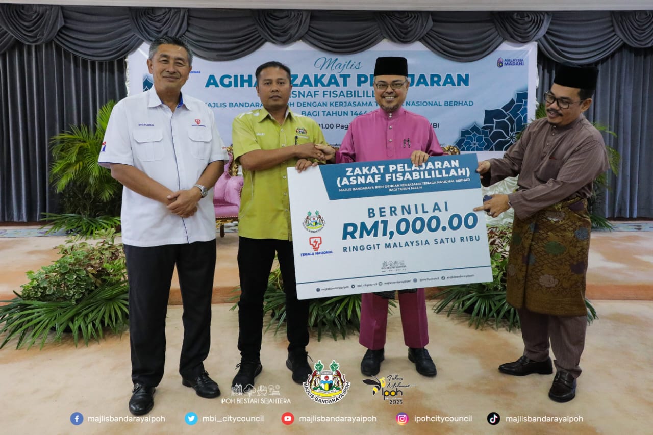 Rumaizi bersama Sharuddin (kiri) menyampaikan sumbangan zakat pelajaran kepada salah seorang kakitangan MBI.