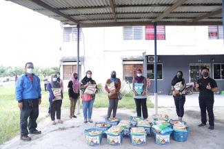 Juruteknik Bahagian Senggaraan Elektrik TNB, Mohd Jamil Ramlan (kiri) menyerahkan sumbangan Ihya' Ramadhan 1442H kepada 30 buah keluarga di Rumah Pangsa Taman Hijau, Sitiawan, Perak pada 27 April lalu.