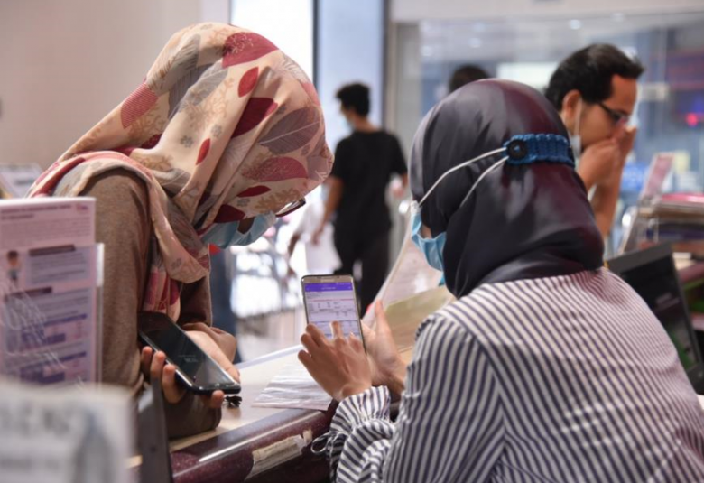 Kakitangan di TNB, menunjukkan penggunaan aplikasi myTNB kepada pelanggan. 