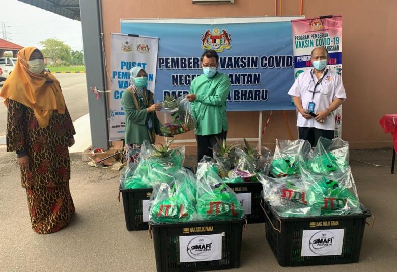  Che Abdullah (tengah) menyampaikan Sumbangan MAFI Prihatian kepada 80 orang petugas barisan hadapan di Pusat Pemberian Vaksin, Dewan Sri Tunjong, Jabatan Pendidikan Negeri Kelantan, semalam.