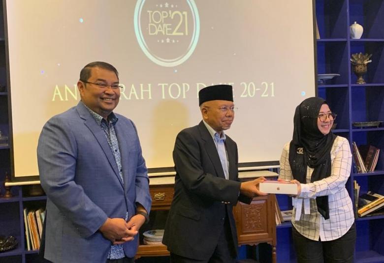 (Dari kiri) Ariffin Sabirin bersama Datuk Ahmad Tajudin (tengah) menyampaikan hadiah kepada salah seorang daie di majlis makan tengah hari di ibu kota hari ini.